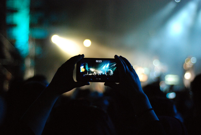 A person recording on a phone at a festival - CC0 (Pixabay)