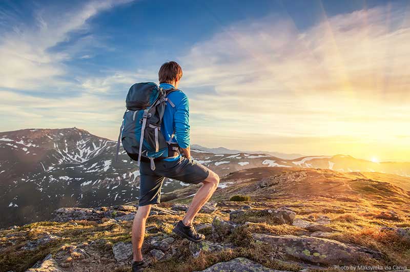 7 Tips for Your First Backpacking Adventure Backpacker on top of a mountain