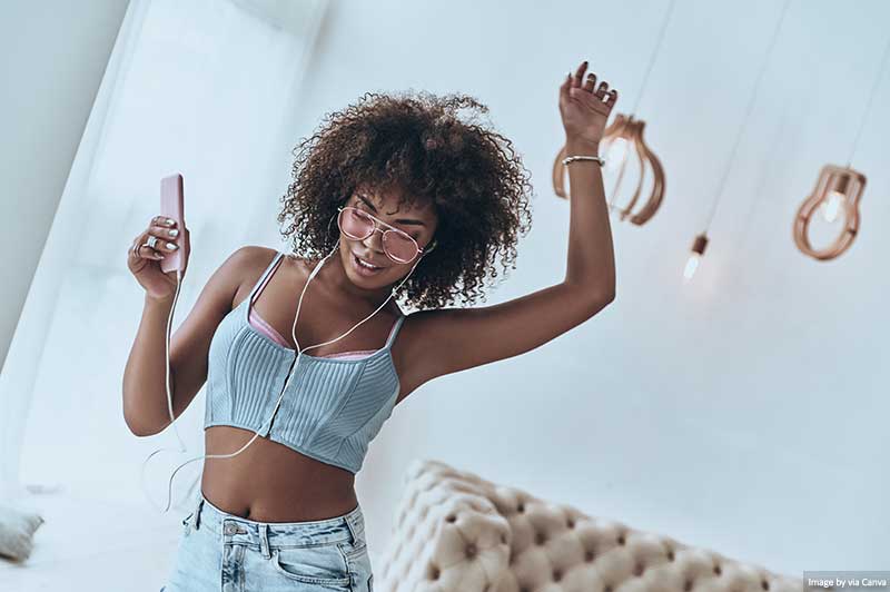 Lady listening to music and dancing with headphones